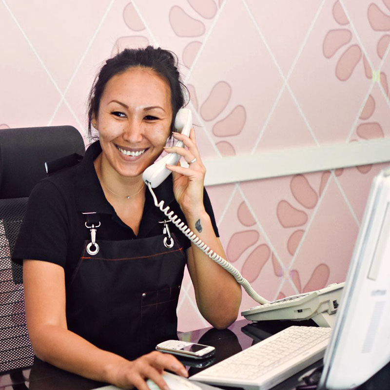 team member smiling on a telephone call at their desk